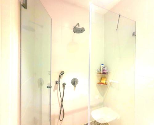 La salle de bains est pourvue d'une douche avec une porte en verre. dans l'établissement Spacious New 1BD Levinski Florentin, à Tel Aviv