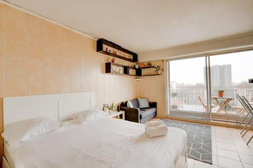 1 dormitorio con 1 cama, 1 silla y 1 ventana en Elegant apartment in Le Pré-Saint-Gervais, en Le Pré-Saint-Gervais
