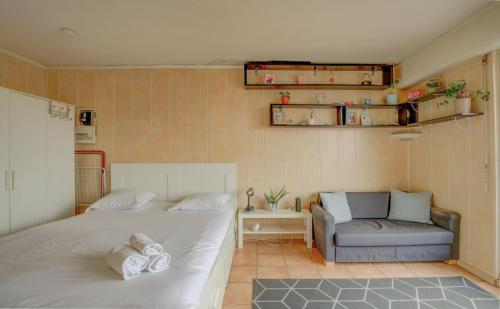 1 dormitorio con cama y sofá en Elegant apartment in Le Pré-Saint-Gervais, en Le Pré-Saint-Gervais