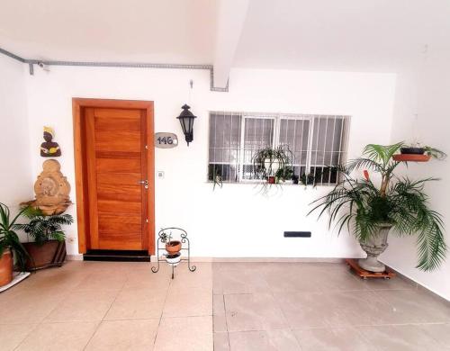 聖保羅的住宿－Casa 146 - SP Expo, Metrô, Congonhas，一间拥有白色墙壁、门和植物的房间