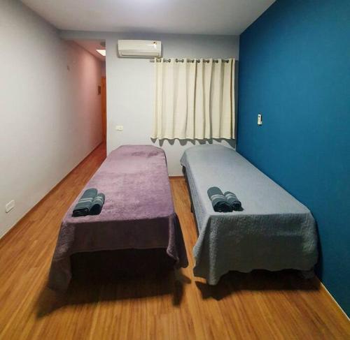 Duas camas num quarto com paredes azuis e pisos em madeira em Casa 146 - SP Expo, Metrô, Congonhas em São Paulo