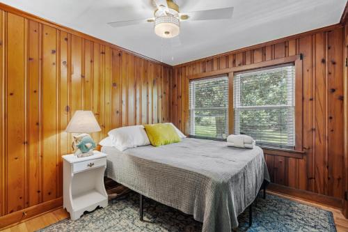 威爾明頓的住宿－Cargo District Vintage Vibes，一间卧室设有木墙和一张带灯的床