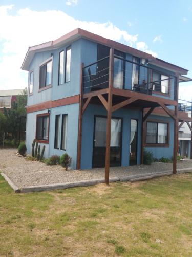 una casa con balcón en la parte superior en Aroma de mar, en Sauce de Portezuelo