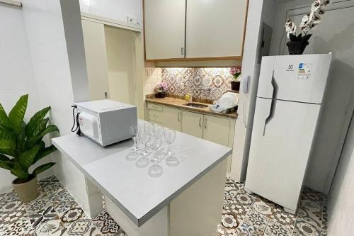 a kitchen with a counter with wine glasses and a refrigerator at Apartamento Copanema Subway Family HIR 27 in Rio de Janeiro