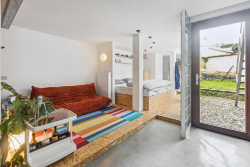 sala de estar con sofá y cama en Cosy art studio near station with bikes and garden en Ghent