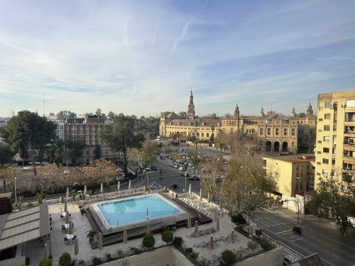 vista su una città con piscina e edifici di Estupendo apartamento junto a Plaza de España a Siviglia