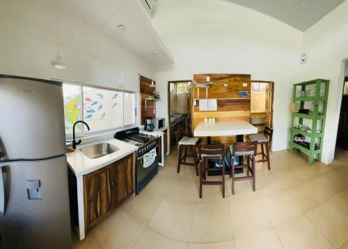 a kitchen with a sink and a table with chairs at Casita Miss Sam en el Centro de Puerto Viejo in Puerto Viejo
