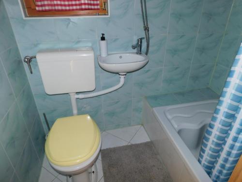 a bathroom with a yellow toilet and a sink at Hansel and Gretel House in Ptuj