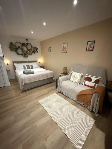 a bedroom with two beds and a couch at The Hive - Cosy Studio in Wells City Centre in Wells