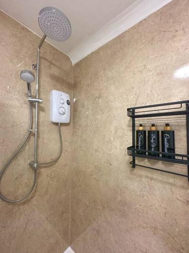 a shower with a shower head in a bathroom at The Hive - Cosy Studio in Wells City Centre in Wells