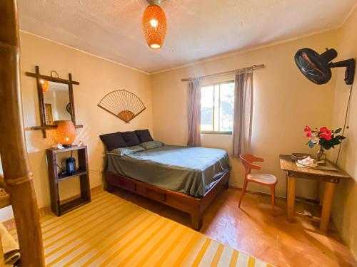 1 dormitorio con 1 cama, 1 mesa y 1 silla en La Hacienda Hostel en Las Galeras