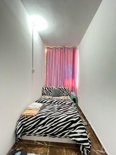 a zebra print bed in a room with a window at Tanih's Lodging in Abu Dhabi