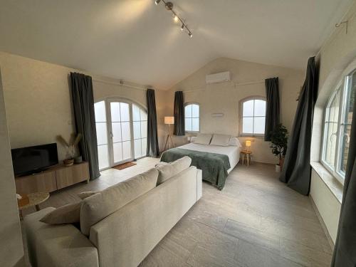 a living room with a bed and a couch at Le Mas de Corenne in Corenne
