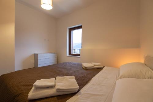 a bedroom with a bed with two towels on it at Coppito Apartment in Coppito