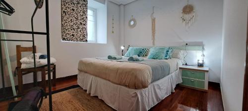una camera da letto con letto e cuscini blu di Apartamento en Mioño a Castro-Urdiales