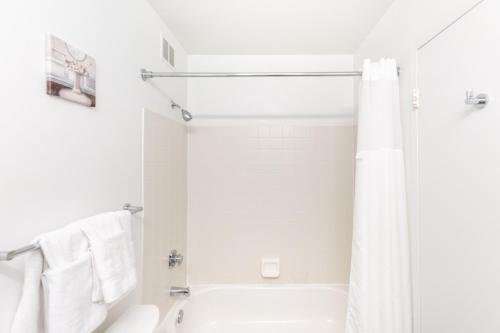 a white bathroom with a shower and a toilet at ENVITAE 3BR Luxury Corner Loft with Navy Pier Views in Chicago