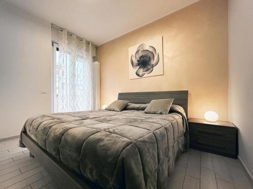 een slaapkamer met een groot bed en een raam bij "La Casetta dei Ronchi" 300 mt dal mare - posto auto gratuito in Marina di Massa