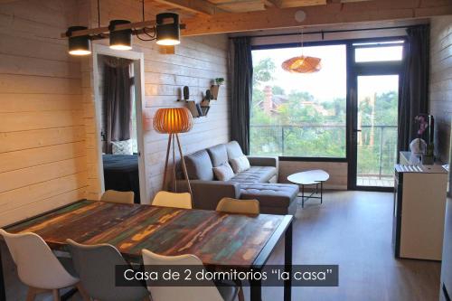ein Wohnzimmer mit einem Tisch und einem Sofa in der Unterkunft NidoGredos Cabañas Ecológicas de Diseño in El Tiemblo