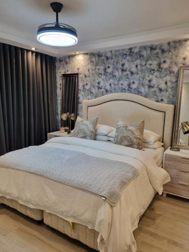 a bedroom with a large bed with floral wallpaper at Soho Luxury Penthouse in Sandton