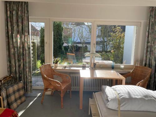 a bedroom with a desk and a bed and a window at Dünenrose 21 in Norderney