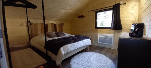 um quarto com uma cama, uma janela e um tapete em Chalet le p'ti lu em Bussang