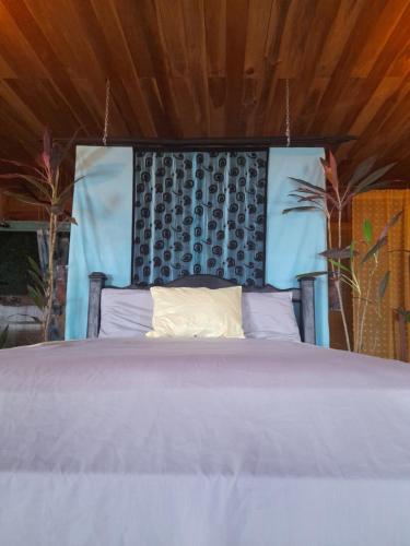 a bedroom with a large bed with a wooden ceiling at Old Bank Tea Garden in Bocas del Toro