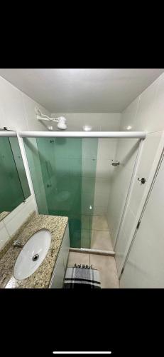 baño con lavabo y pared de cristal en Apartamento em Arraial do Cabo, en Arraial do Cabo