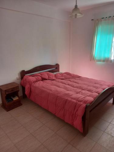 1 dormitorio con 1 cama grande con manta roja en Cabañas Torres Del Sol en Santa María