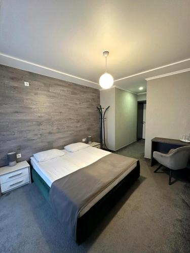 a bedroom with a large bed and a desk at Garden Hall in Ternopilʼ