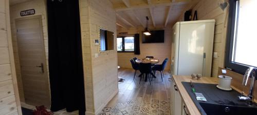 a kitchen and dining room of a tiny house at Chalet le p'ti lu in Bussang