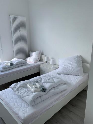 a bedroom with two beds with white sheets and pillows at Hochstrasse 10 in Unna