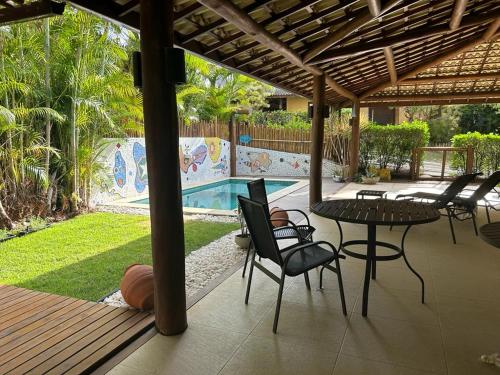 un patio con mesa y sillas junto a una piscina en Pássaros, en Mata de Sao Joao