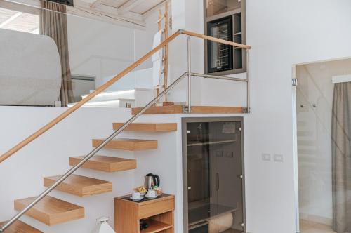 a staircase in a house with white walls and wooden steps at Masseria Longa Boutique Hotel in Otranto