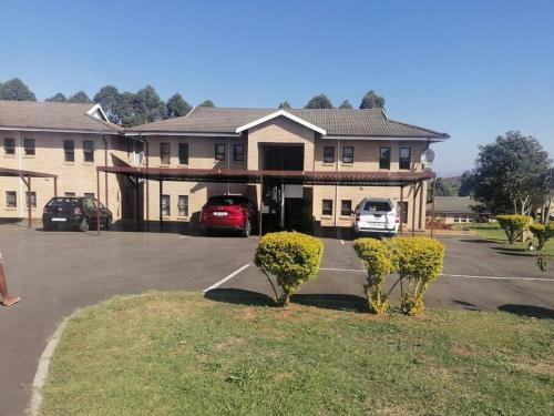 a large building with a parking lot with cars parked at Peaceful Home with Sbo in Pietermaritzburg