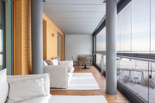 a living room with white furniture and a large window at Top, cozy, lakeside, sauna and free indoor parking in Tampere