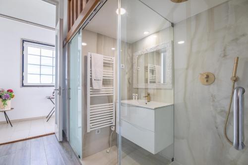 a bathroom with a glass shower and a sink at Deluxe Spacious Flats w Mezzanine by Host Wise in Porto
