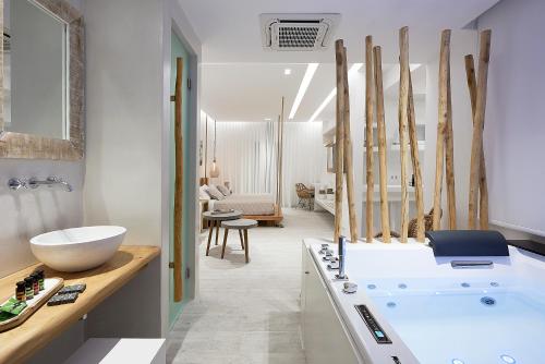 a bathroom with a white tub and a sink at Nirome Luxury Suites in Adamantas