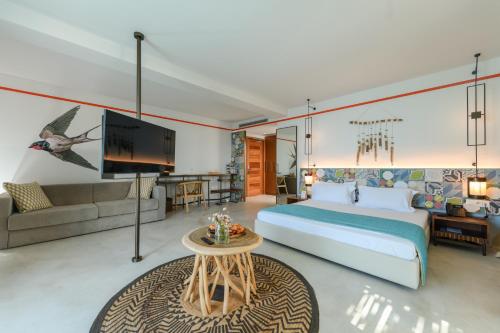 a bedroom with a large bed and a couch at Folie Marine Hotel & Beach Club in Jal