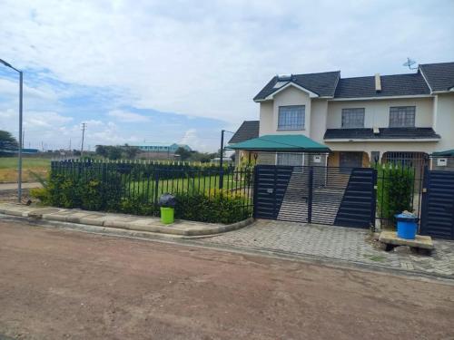 uma cerca em frente a uma casa em Vacay interprime villa #10 em Kitengela 