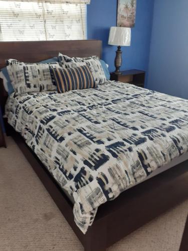 Una cama con edredón en un dormitorio en Beautiful St Pete Beach, FL 2nd Floor 2BR Unit, en St Pete Beach
