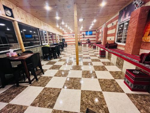 a restaurant with a checkerboard floor and tables and chairs at Petra Royal Ranch in Wadi Musa