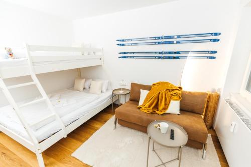 - un salon avec des lits superposés et un canapé dans l'établissement HEIMATEL - Ferienwohnungen Steibis, à Oberstaufen