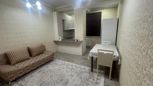 uma sala de estar com um sofá e uma mesa em Апартамент NUR em Bishkek