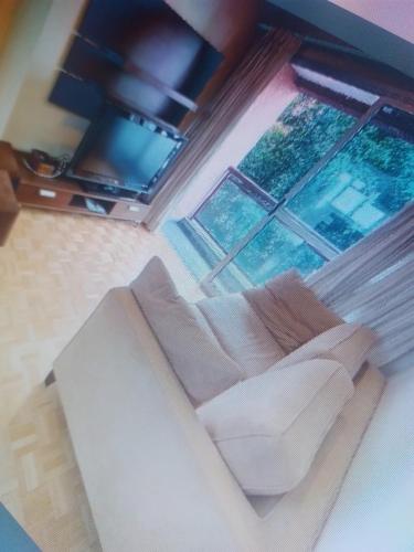 uma sala de estar com um sofá e uma grande janela em Casa da em Salvador