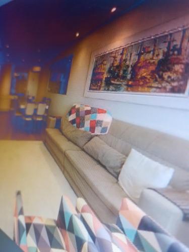 um sofá numa sala de estar com um quadro na parede em Casa da em Salvador