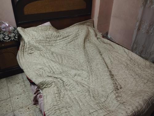 ein Bett mit einer Decke darüber in der Unterkunft شقة in Aţ Ţarfāyah