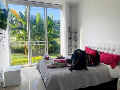 a bedroom with a bed with a large window at Hermosa casa campestre! in Ibagué