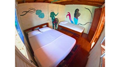 1 dormitorio con 1 cama y una pintura en la pared en Posada nativa casa azul, en Playa Blanca