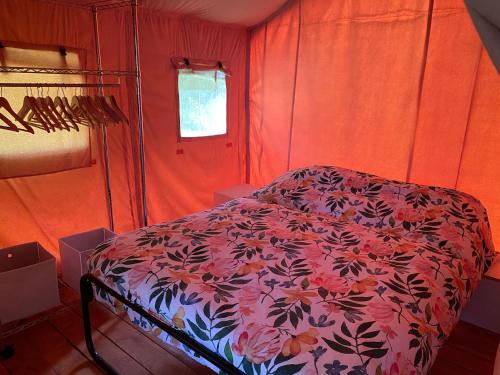 een rode kamer met een bed met een bloemenpatroon bij Safari tent in Magyarhertelend