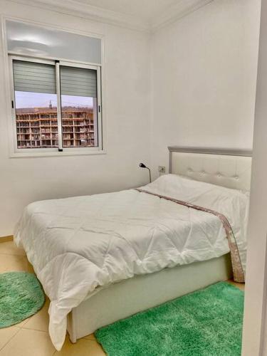 - une chambre blanche avec un lit et une fenêtre dans l'établissement Coquette studio 7 min plage, à Agadir